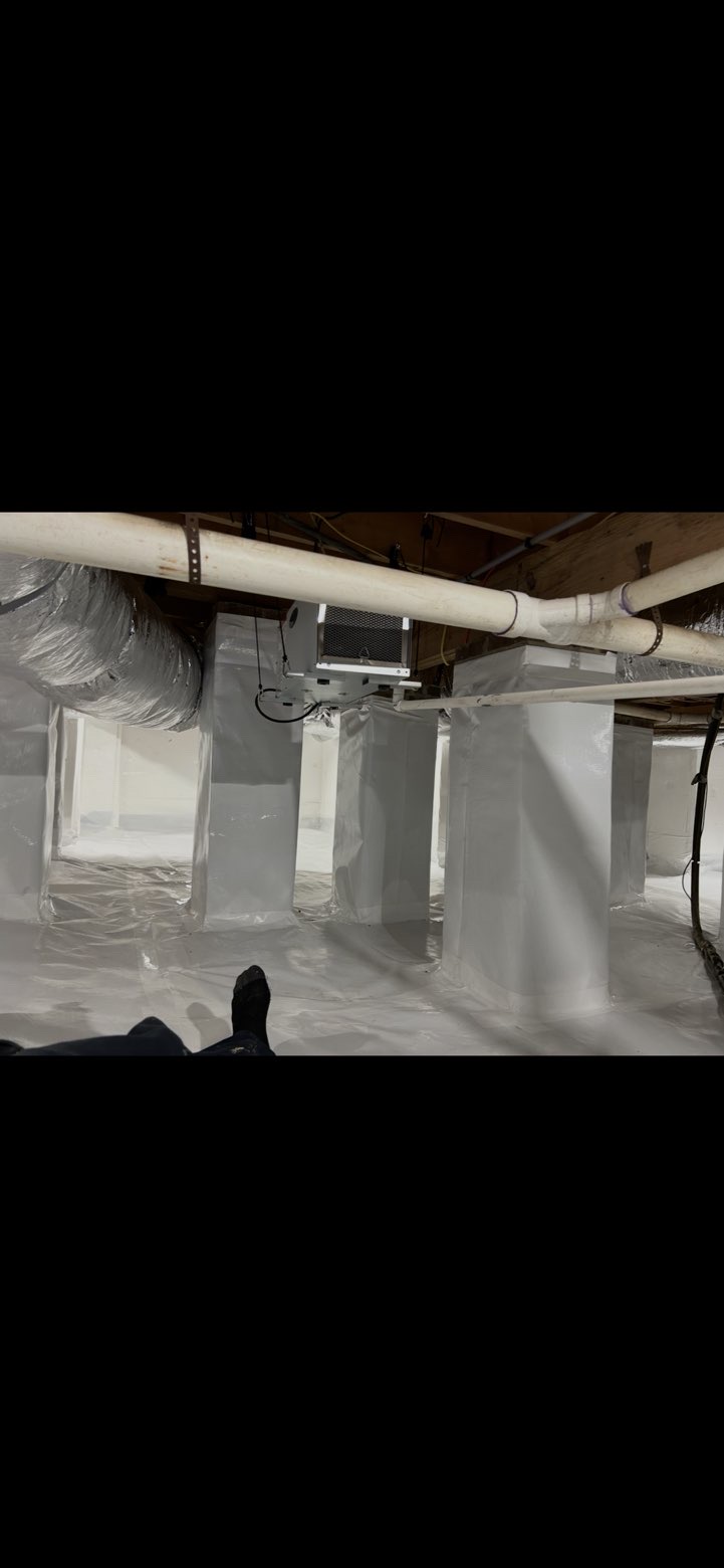 Encapsulated crawlspace with sealed white vapor barrier and visible HVAC ducts