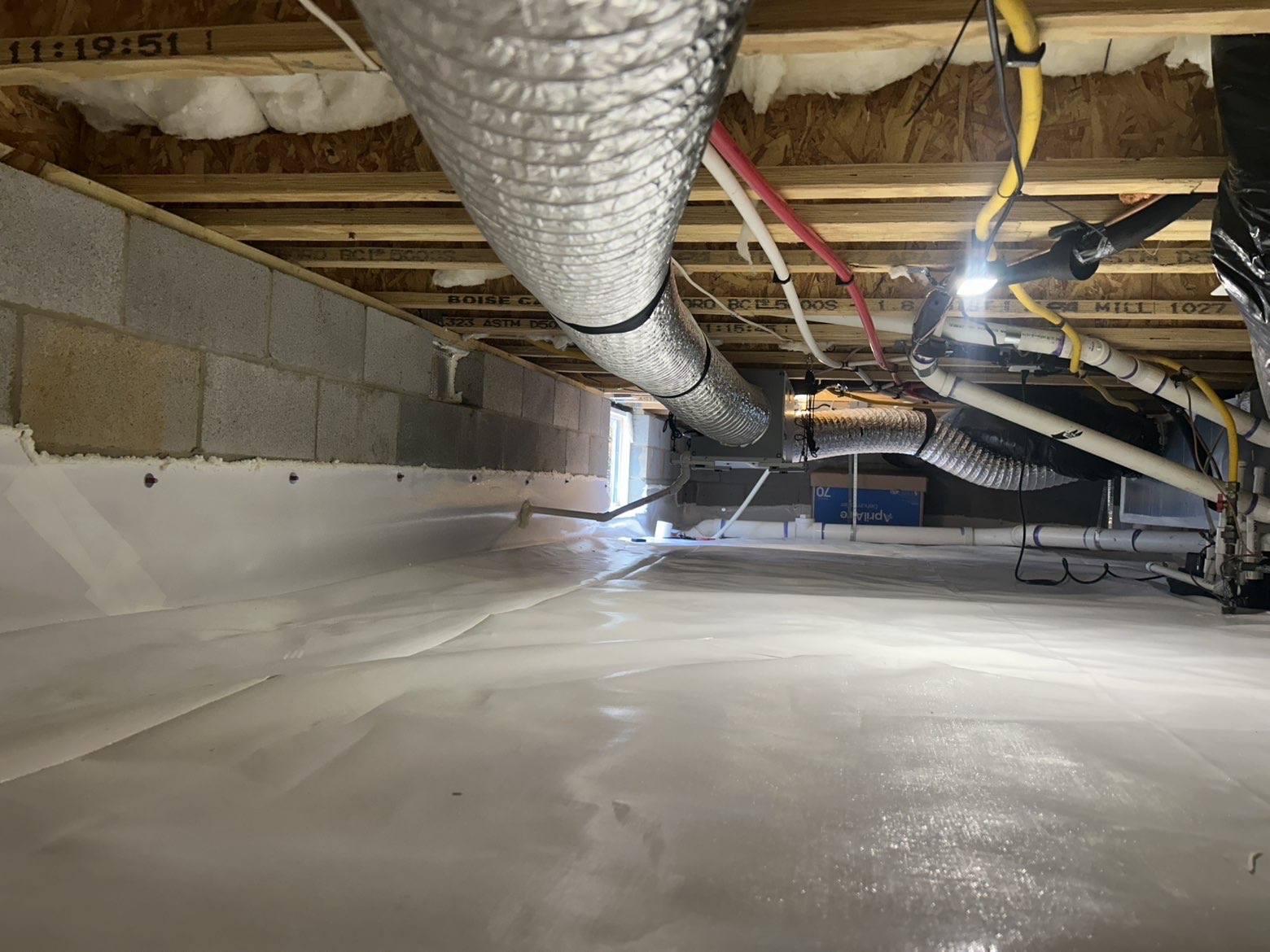 Support piers wrapped and sealed with white plastic vapor barrier in completed encapsulation