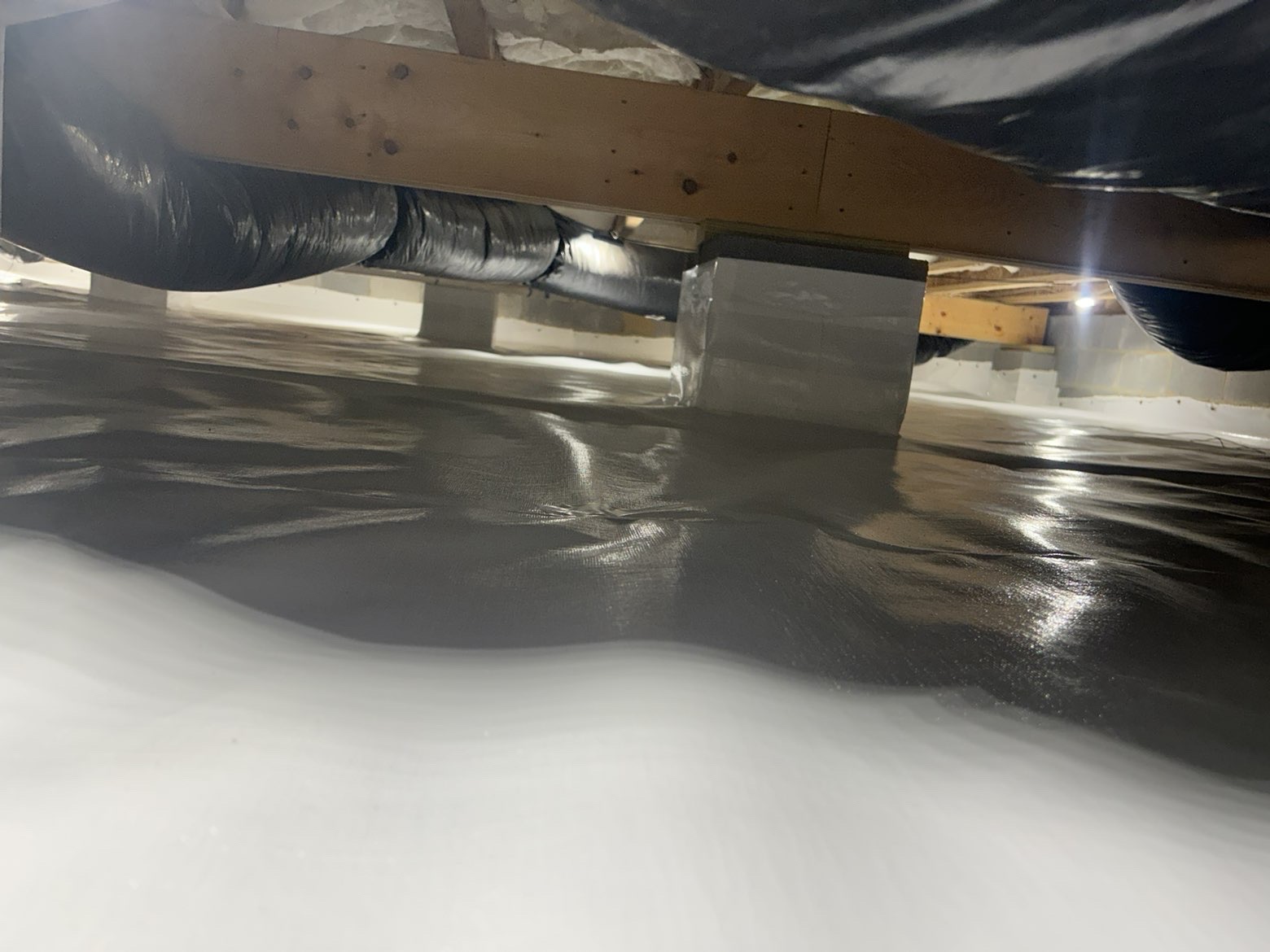 Fully wrapped foundation support piers with sealed white vapor barrier moisture protection
