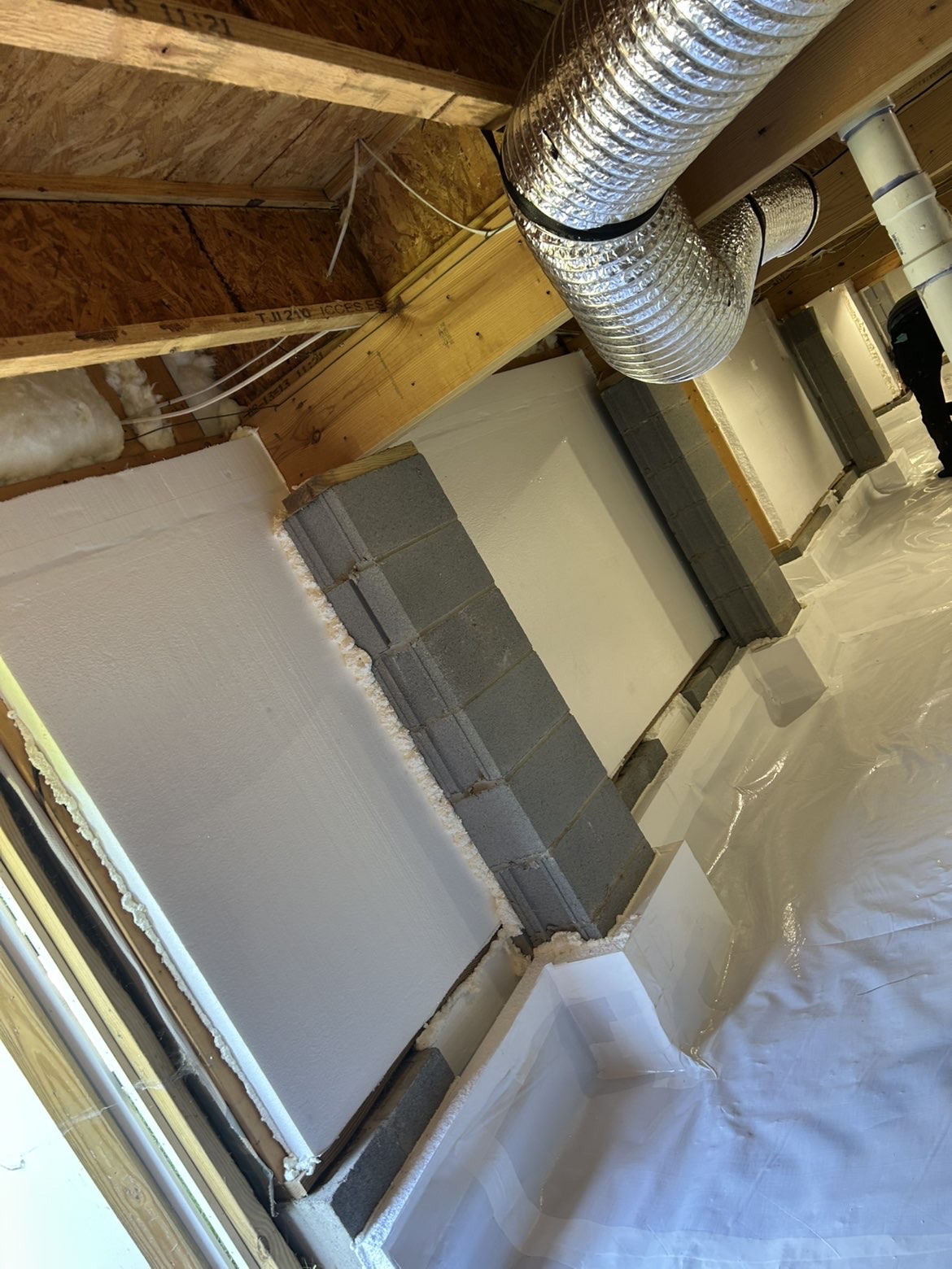 Encapsulated crawlspace with dehumidifier unit and sealed white vapor barrier system